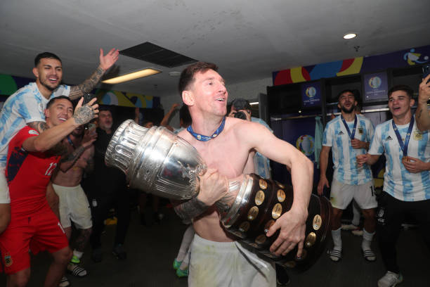 Lionel Messi of Argentina celebrates with the trophy and teammates in the locker room after the final of Copa America Brazil 2021 between Brazil and...