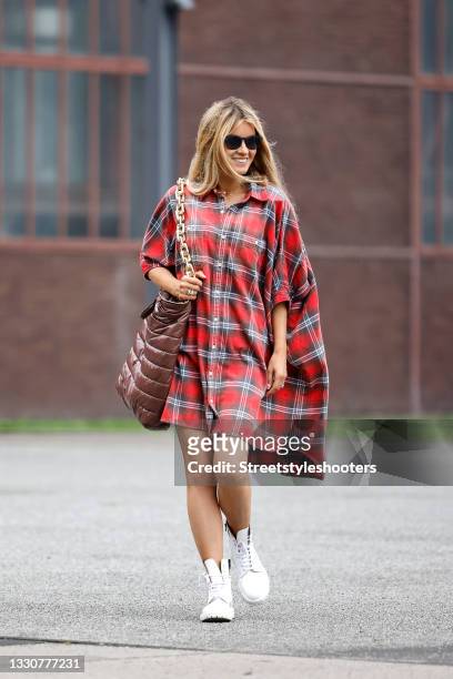Influencer Gitta Banko wearing a red checkered blouse dress by R13, white boots by Common Projects, sunglasses by Ray-Ban and a brown bag with gold...