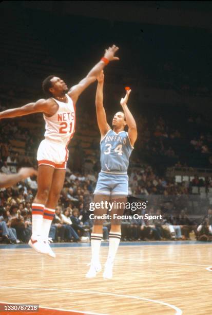 John Shumate of the Buffalo Braves shoots over Tim Bassett of the New Jersey Nets during an NBA basketball game circa 1977 at the Rutgers Athletic...