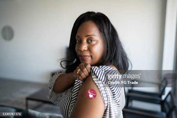 portrait d’une femme d’âge mûr montrant un bras avec l’autocollant « je me fais vacciner » sur - clothing shot flat photos et images de collection