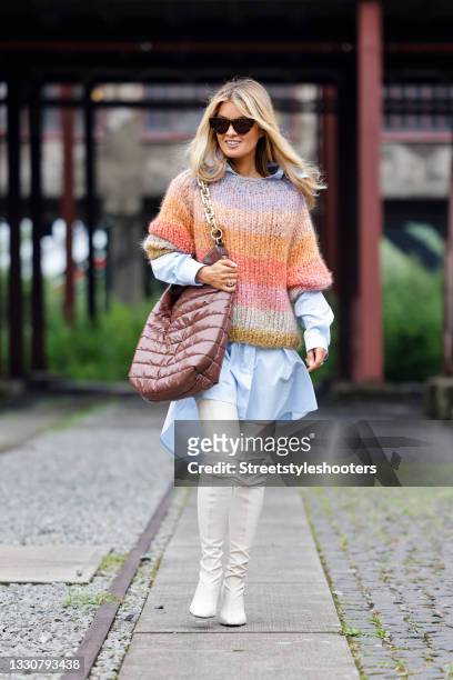 Influencer Gitta Banko wearing a pastel blue oversized blouse dress with eagle print by Margiela, cream colored high heel overknee boots by Proenza...