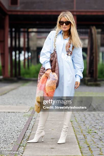 Influencer Gitta Banko wearing a pastel blue oversized blouse dress with eagle print by Margiela, cream colored high heel overknee boots by Proenza...