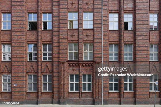 exterior front street view of rough vintage red brick classical facade of typical old building in berlin, germany. - berlin wall stockfoto's en -beelden