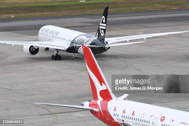 An Air New Zealand aircraft and an Qantas aircraft on the arrivals apron at Kingsford Smith International airport on July 26, 2021 in Sydney,...