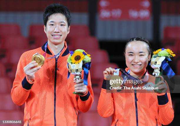 Gold medalists Mima Ito and Jun Mizutani of Team Japan pose for photographs at the medal ceremony for the Mixed Doubles on day three of the Tokyo...