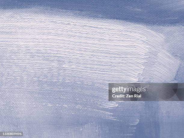 white paint brush stroke on painted blue canvas - canvas stockfoto's en -beelden