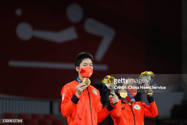 Gold medalists Jun Mizutani and Mima Ito of Japan celebrate on the podum after winning the Mixed Doubles Gold Medal Match against Xu Xin and Liu...