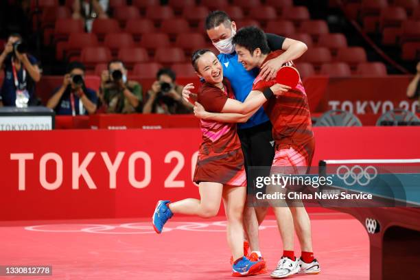 Jun Mizutani and Mima Ito of Japan celebrate with their coach after winning the Mixed Doubles Gold Medal Match against Xu Xin and Liu Shiwen of China...