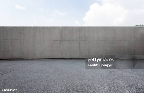 empty parking lot and concrete wall - wall foto e immagini stock
