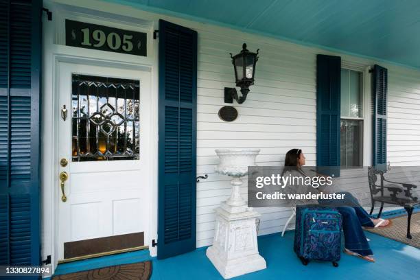 ein weiblicher gast sitzt auf der veranda von t'frere's b & b, einem cajun akadischen kolonialhaus aus roter zypresse, lafayette, louisiana, usa - lafayette louisiana stock-fotos und bilder