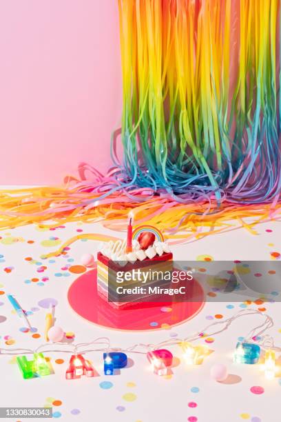 birthday party decorations ideas of rainbow cake and tinsel - rainbow confetti stock pictures, royalty-free photos & images