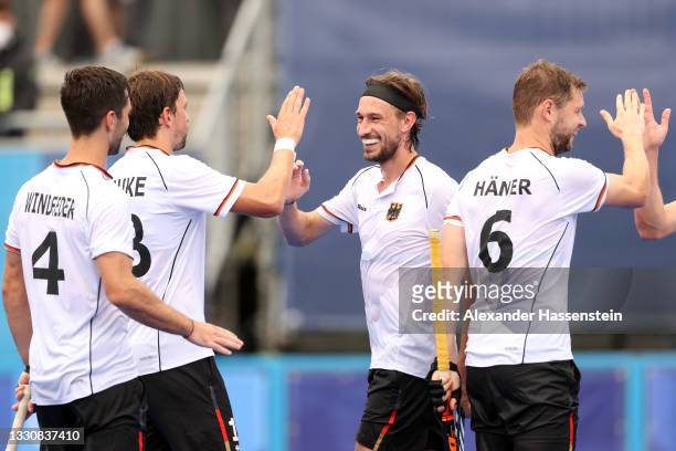Florian Fuchs of Team Germany scores the fifth goal and celebrates with teammates during the Men's Preliminary Pool B match between Great Britain and...