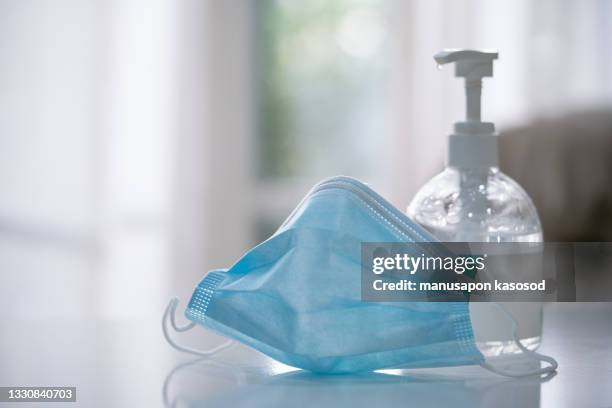 alcohol gel and face mask to prevent virus covid-19 - infection prevention stockfoto's en -beelden