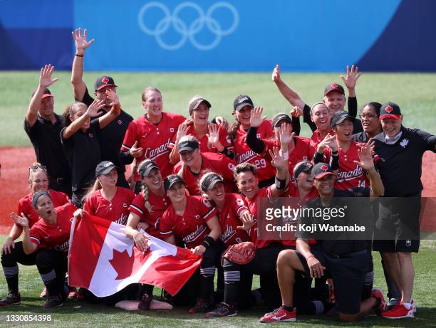 Team Canada pose for a group photo with their flag after defeating Team Mexico 3-2 in the women's bronze medal softball game between Team Mexico and...