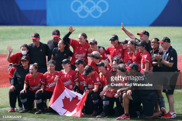Team Canada pose for a group photo with their flag after defeating Team Mexico 3-2 in the women's bronze medal softball game between Team Mexico and...