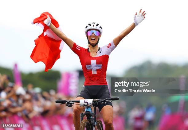 Jolanda Neff of Team Switzerland celebrates winning the gold medal while holding the flag of his country on arrival during the Women's Cross-country...