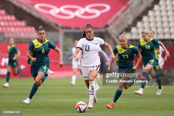 Alex Morgan of Team United States breaks away from Chloe Logarzo and Tameka Yallop of Team Australia during the Women's Football Group G match...
