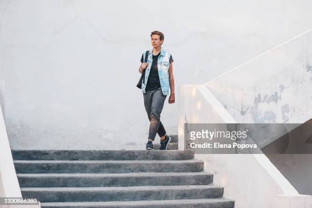 young adult woman walking in the city and moving down the stairs - woman walks down street stock pictures, royalty-free photos & images