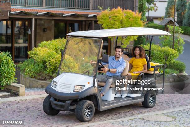 hotel employee ride tourist woman with luggage in golf cart to the hotel room - country club stock pictures, royalty-free photos & images