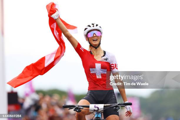 Jolanda Neff of Team Switzerland celebrates winning the gold medal while holding the flag of his country on arrival during the Women's Cross-country...