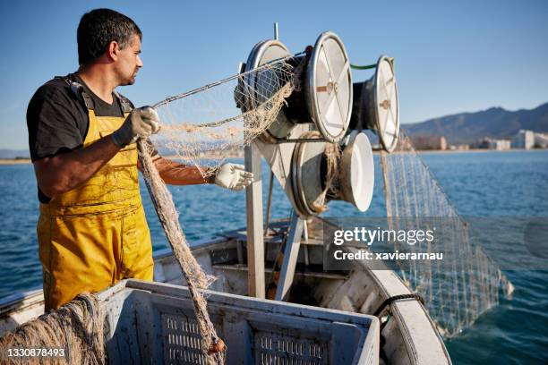 commercial fisherman reeling in net with winch - trawler net stock pictures, royalty-free photos & images