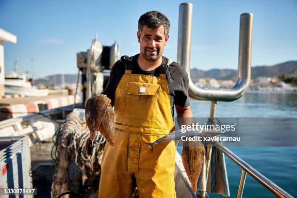 portrait of independent fisherman holding fresh catch - professionele visser stockfoto's en -beelden