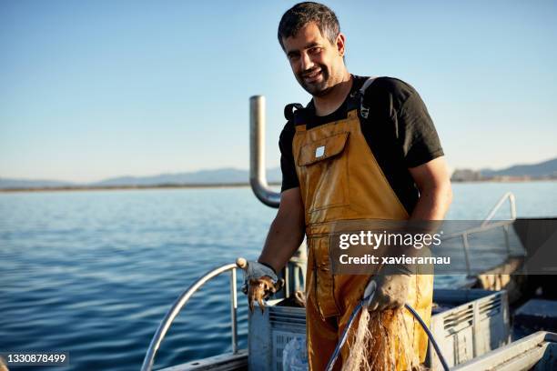 candid portrait of fisherman holding net and cuttlefish - fisher man imagens e fotografias de stock