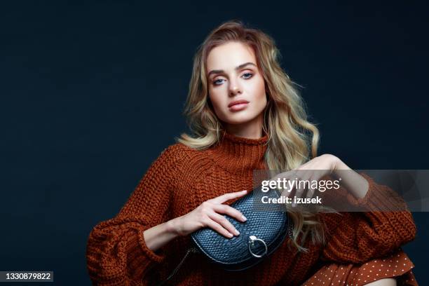 retrato de moda de mujer elegante con ropa marrón, fondo oscuro - fashion model bag fotografías e imágenes de stock