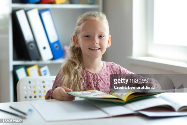 happy child doing homework with book - book table stockfoto's en -beelden