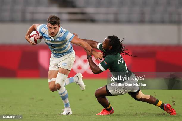 Santiago Alvarez of Team Argentina fends off the tackle from Branco du Preez of Team South Africa during the Rugby Sevens Men's Quarter-final match...