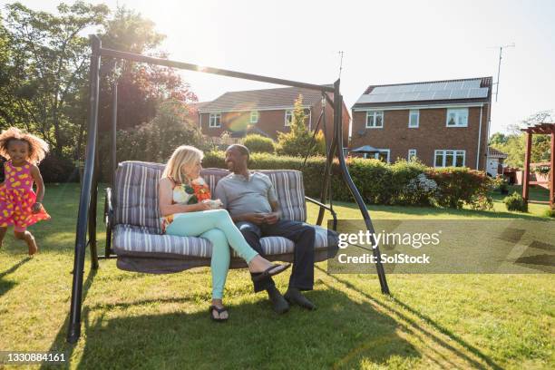 supervising their granddaughter while they swing - couple swinging stock pictures, royalty-free photos & images