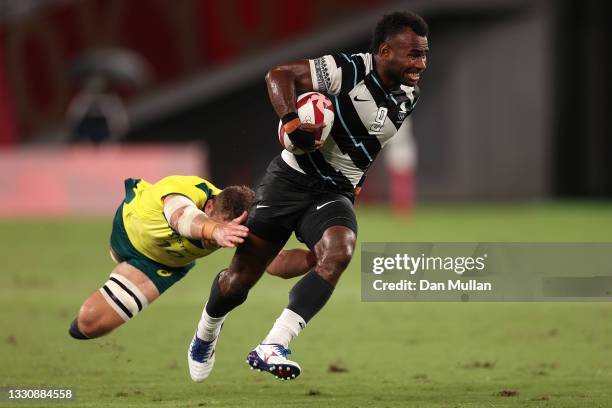 Jerry Tuwai of Team Fiji makes a break past Nick Malouf to score a try during the Rugby Sevens Men's Quarter-final match between Australia and Fiji...