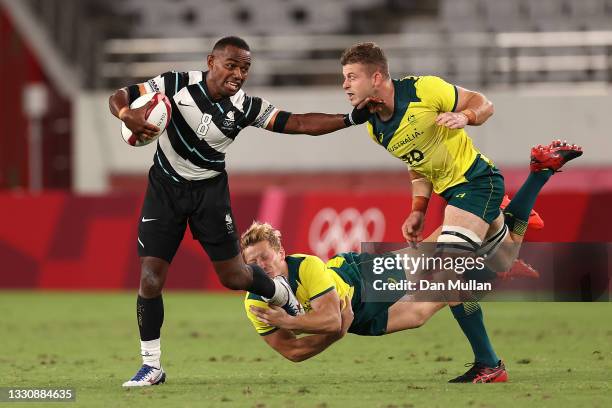 Waisea Nacuqu of Team Fiji is tackled by Lachie Miller and Nick Malouf of Team Australia during the Rugby Sevens Men's Quarter-final match between...