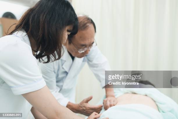 doctor and nurse are treating a patient - acupuncture elderly stock pictures, royalty-free photos & images