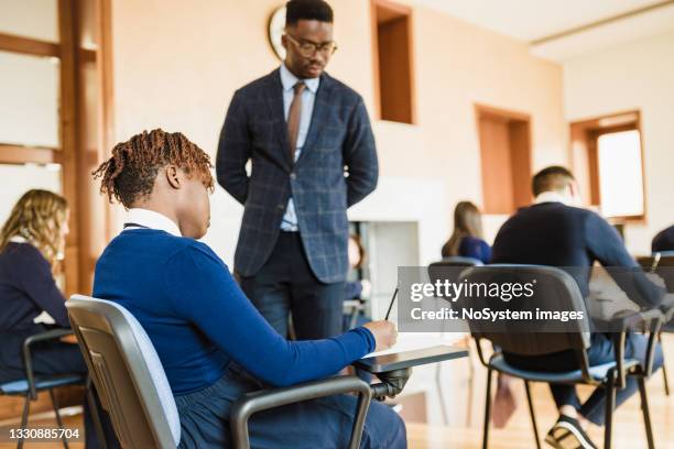 teacher supervising the class during a school exam - school exam stock pictures, royalty-free photos & images