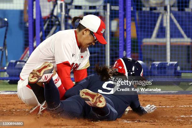 Janette Reed of Team United States slides into home plate as Yukiko Ueno of Team Japan makes the out in the first inning during the Softball Gold...