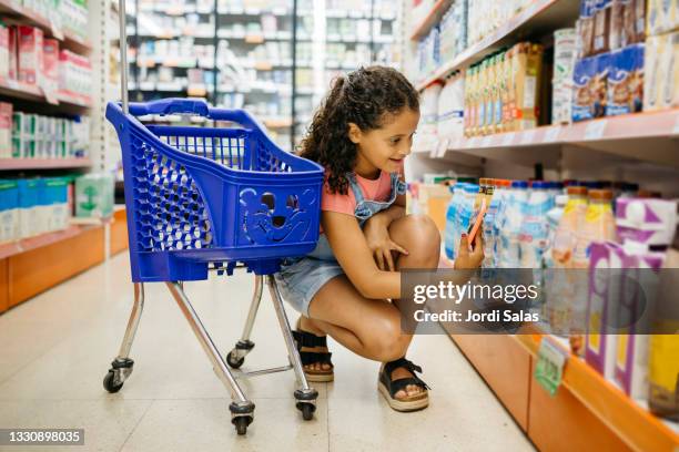 girl shopping in a supermarket - supermarkt gang stock-fotos und bilder