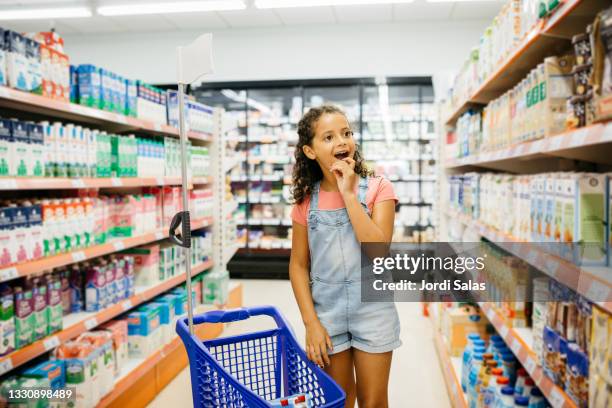 girl shopping in a supermarket - supermarkt gang stock-fotos und bilder
