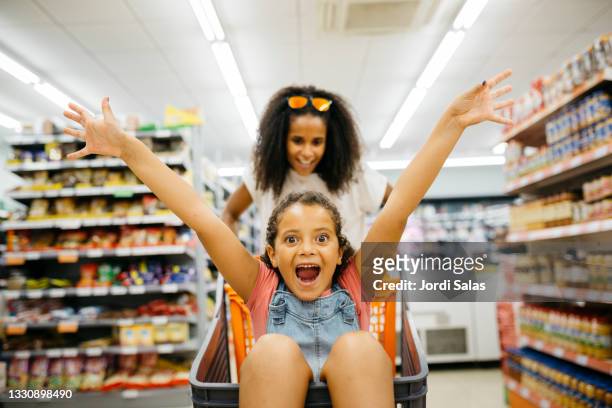mother and her daughter shopping in a supermarket - shopping cart groceries stockfoto's en -beelden
