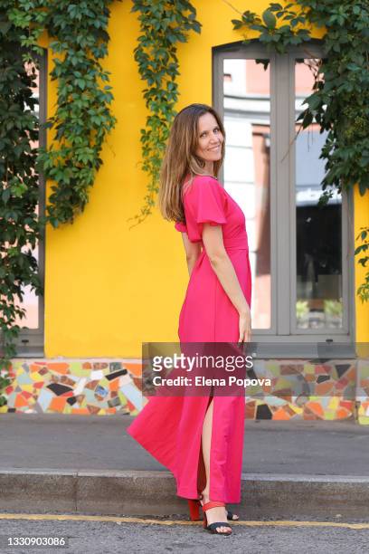 young beautiful woman in long pink dress walking on the street - yellow dress stock pictures, royalty-free photos & images