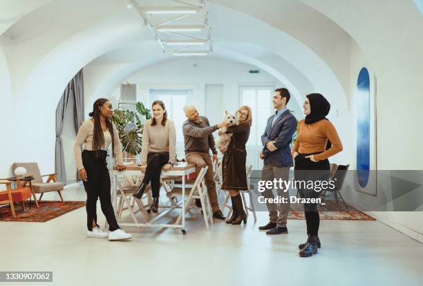 group of business people standing in pet friendly office after reopening - west highland white terrier stock pictures, royalty-free photos & images