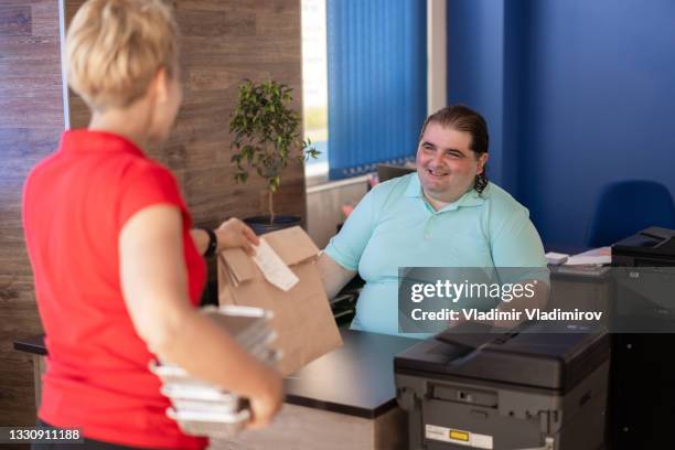 overweight man receives food delivery at desk - large printer stock pictures, royalty-free photos & images