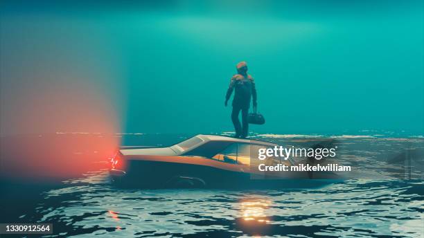 car sinks into water while driver escapes and stands on the roof - escapism stock pictures, royalty-free photos & images
