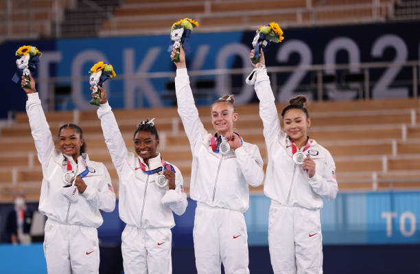 Jordan Chiles, Simone Biles, Grace McCallum and Sunisa Lee of Team United States react on the podium after winning the silver medal during the...