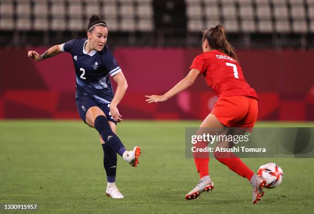 Lucy Bronze of Team Great Britain passes the ball whilst under pressure from Julia Grosso of Team Canada during the Women's Group E match between...
