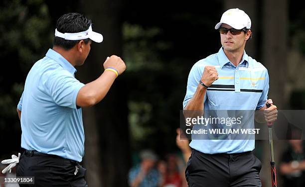 International Team pairing of Australian Adam Scott and K.J. Choi of South Korea celebrate on the way to defeating the US pairing of Tiger Woods and...