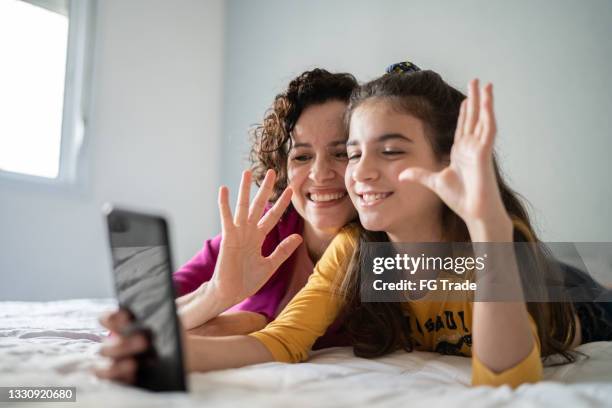 mother and daughter doing a video call on smartphone at home - misses vlog stock pictures, royalty-free photos & images