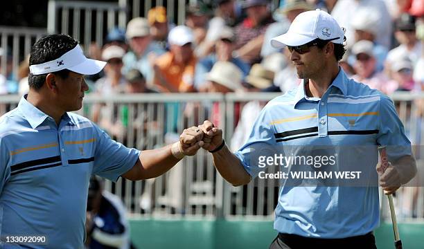 Australian Adam Scott and International teammate K.J. Choi of South Korea celebrate during their President's Cup tournament match played at the Royal...