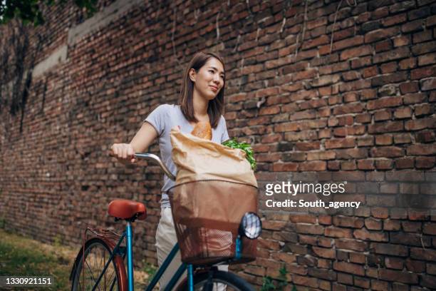 frau war beim einkaufen für lebensmittel mit fahrrad - shopping with bike stock-fotos und bilder