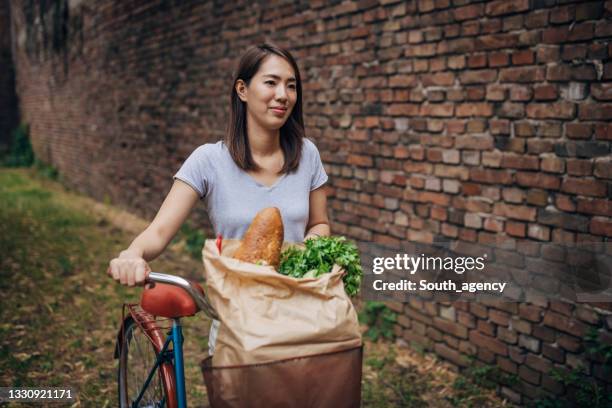 woman was in shopping for groceries with bicycle - bicycle basket stock pictures, royalty-free photos & images